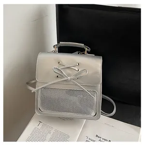 Detail showing silver metallic backpack with bow ribbon and mesh window texture