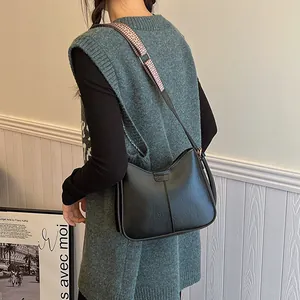 Retro black leather hobo bag with a colorful woven strap shown on a model