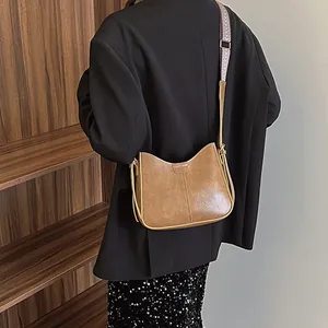 Vintage brown shoulder bag with a stylish woven strap and premium faux leather texture