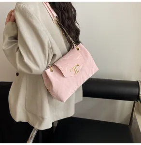 Nahaufnahme der rosa Plissee-Tasche mit goldener T-Logo-Hardware und Kettenriemen