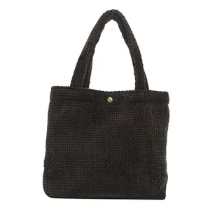 Fashionable dark brown woven tote bag with chunky knit texture and gold button detail