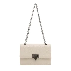 Bolso bandolera crema con textura tejida y cadena metálica para un estilo callejero muy elegante