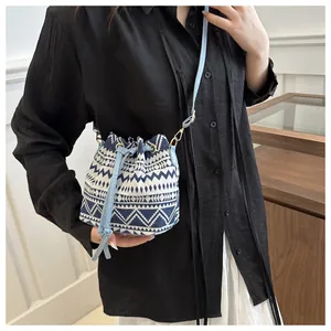 Dettaglio che mostra la borsa a secchiello etnica con motivo geometrico blu e chiusura a coulisse