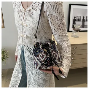 Dettaglio della borsa a secchiello boho con motivo jacquard e chiusura con coulisse in pelle