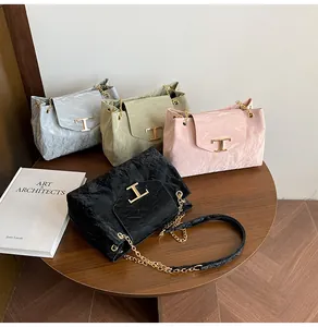 Mehrere plissierte Ledertaschen in verschiedenen Farben mit markanten goldenen T-Schnallen