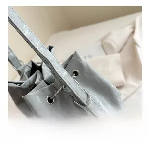 Détail du sac seau gris clair montrant la texture nuageuse et les anneaux métalliques