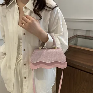 Roze crossbodytas met pailletten en golvende randen gedragen door een model in outfit