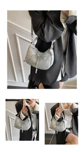Detail of light grey hobo bag showing cloudy texture, bow ribbon and metal logo