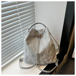 Gros plan détaillé d'un sac seau argenté avec papillon et fermeture à cordon coulissant