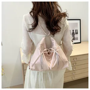 Dettaglio di uno zaino rosa chiaro alla moda con fiocchi decorativi e cerniere d'argento