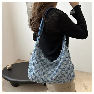 Detail of blue checkerboard denim tote bag featuring trendy frayed edges and soft texture
