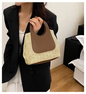 Detail of retro straw tote bag with contrast brown leather handles and woven texture