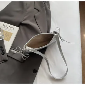 Detail of silver metallic tote bag showing beige fabric lining and interior structure