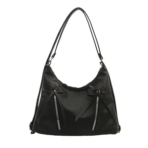 Sac hobo noir minimaliste avec fermetures éclair décoratives et détails de nœuds