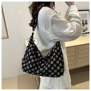 Detail of black and white checkerboard tote bag with fringe texture on a model