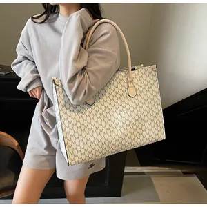Vista laterale dettagliata della grande borsa tote beige con stampa lettere M grigie