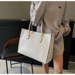Dettaglio della grande borsa tote con stampa a lettere M e borchie metalliche laterali