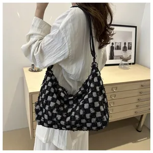 Detail of the black and white checkerboard tweed bag featuring stylish frayed edges
