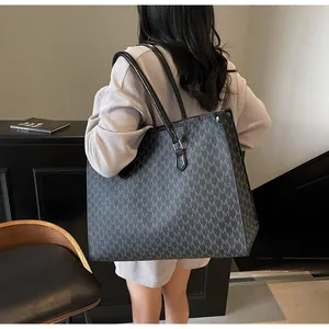 Dettaglio macro della borsa tote grigia grande con motivo monogram e manici resistenti