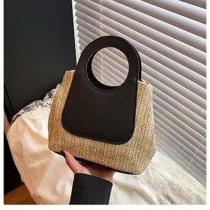 Close-up of woven straw handbag texture with black leather handle in natural light