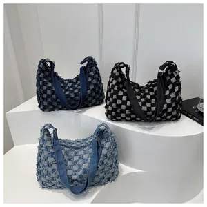Detailed close-up of textured checkerboard hobo bags in blue and black woven fabrics