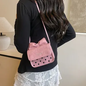 Roze dames crossbody tas met modieuze strik en stippen getoond door een model
