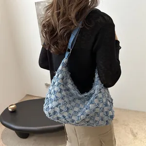 Blue and gray checkerboard denim tote bag with frayed edges and silver buckle detail