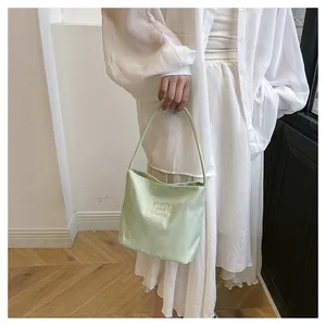 Close-up of pistachio green satin tote bag with white pretty and liboty embroidery
