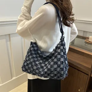 Minimalist blue checkerboard tote bag with frayed edges worn by a model in bright room