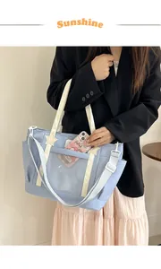 Detail of light blue tote bag with a clear PVC window and white star accents