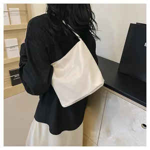 Close-up of creamy white PU leather shoulder bag with pretty and liberty embossed text