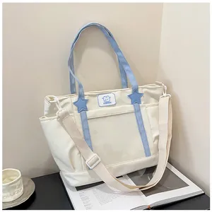 Detail of canvas tote bag with star patches, side pockets, and adjustable strap