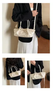 Detailed view of cream bow-knot woven handbag featuring pleated texture and twin handles