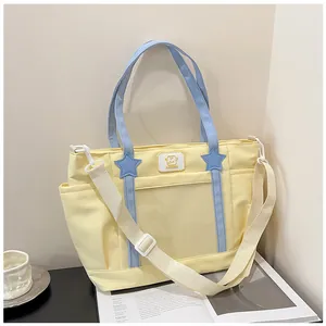 Detail of light yellow nylon tote bag with star charms and adjustable crossbody strap