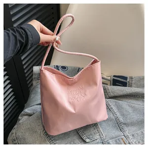Detail of pink nylon bucket bag with pretty and libety embroidery and slim strap
