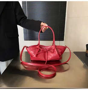 Detail view of red woven handbag featuring elegant ribbon bow and textured pleats