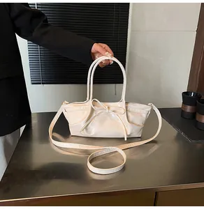 Close-up of a cream woven basket bag with large bow detail and elegant metallic accents