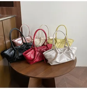 Close-up of woven bucket bags in various colors with bow detail and soft faux leather texture