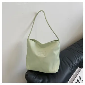 Detail of light green canvas tote bag with pretty and liberty embroidery on the side