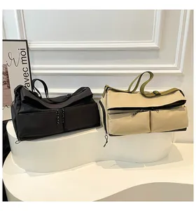 Vue de sacs de voyage noir et beige montrant les poches avant et sangles robustes