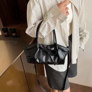Chic black pleated handbag with bow detail and slim shoulder strap for women