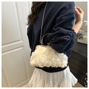 Detailed view of white floral evening clutch with gold chain strap and vintage handle