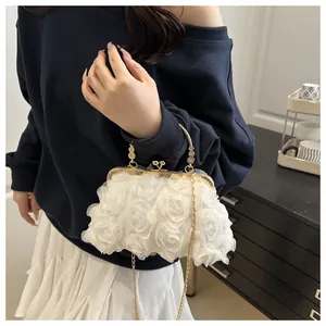 Macro detail of the 3D white organza rose flowers and gold metal clasp on evening clutch