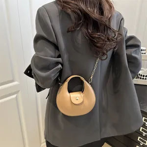 Schicke khakifarbene Halbmondtasche mit goldener Kette zum grauen Blazer Outfit