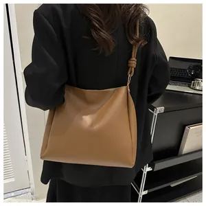 Détail du sac seau marron avec nœud sur la bandoulière pour un style professionnel