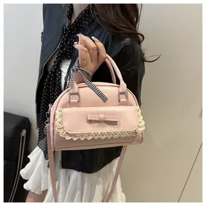 Gros plan d'un sac rose avec bordure en dentelle, détails de nœud et ruban à carreaux
