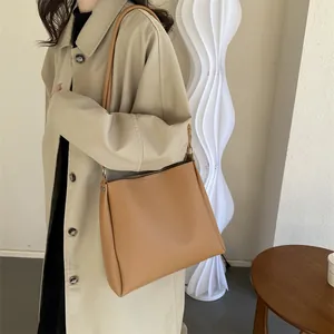 Sac à main minimaliste en cuir beige avec silhouette trapèze pour femme élégante