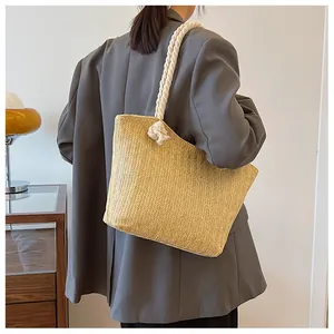 Vue détaillée du sac cabas en paille avec poignées en coton épais sur un mannequin