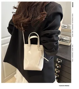 Details der minimalistischen beigen Leder-Umhängetasche mit geflochtenem Anhänger