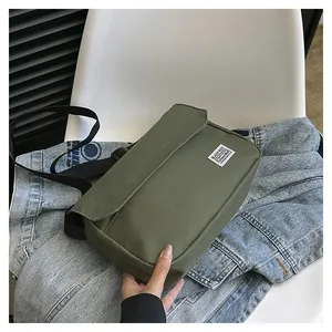 Close-up of military green canvas messenger bag with flap closure and woven strap